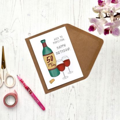 wine aged to perfection 50th birthday card on desk