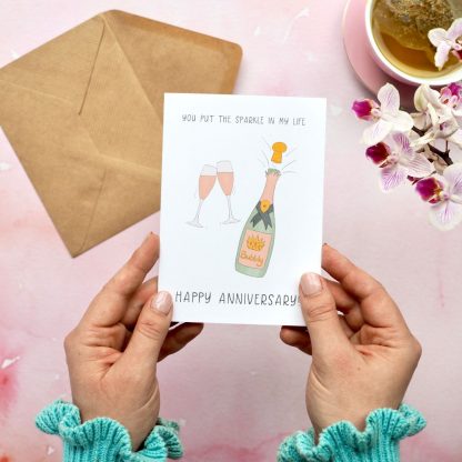 Hands holding Champagne Sparkle Anniversary Card