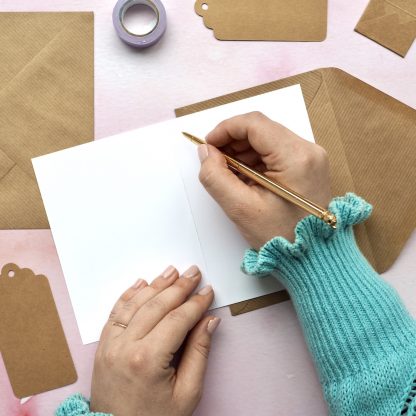 Person writing in greeting card blank inside